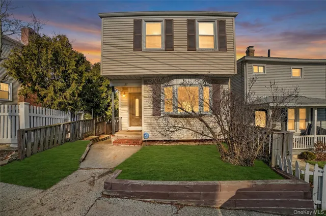 a front view of a house with a yard and potted plants