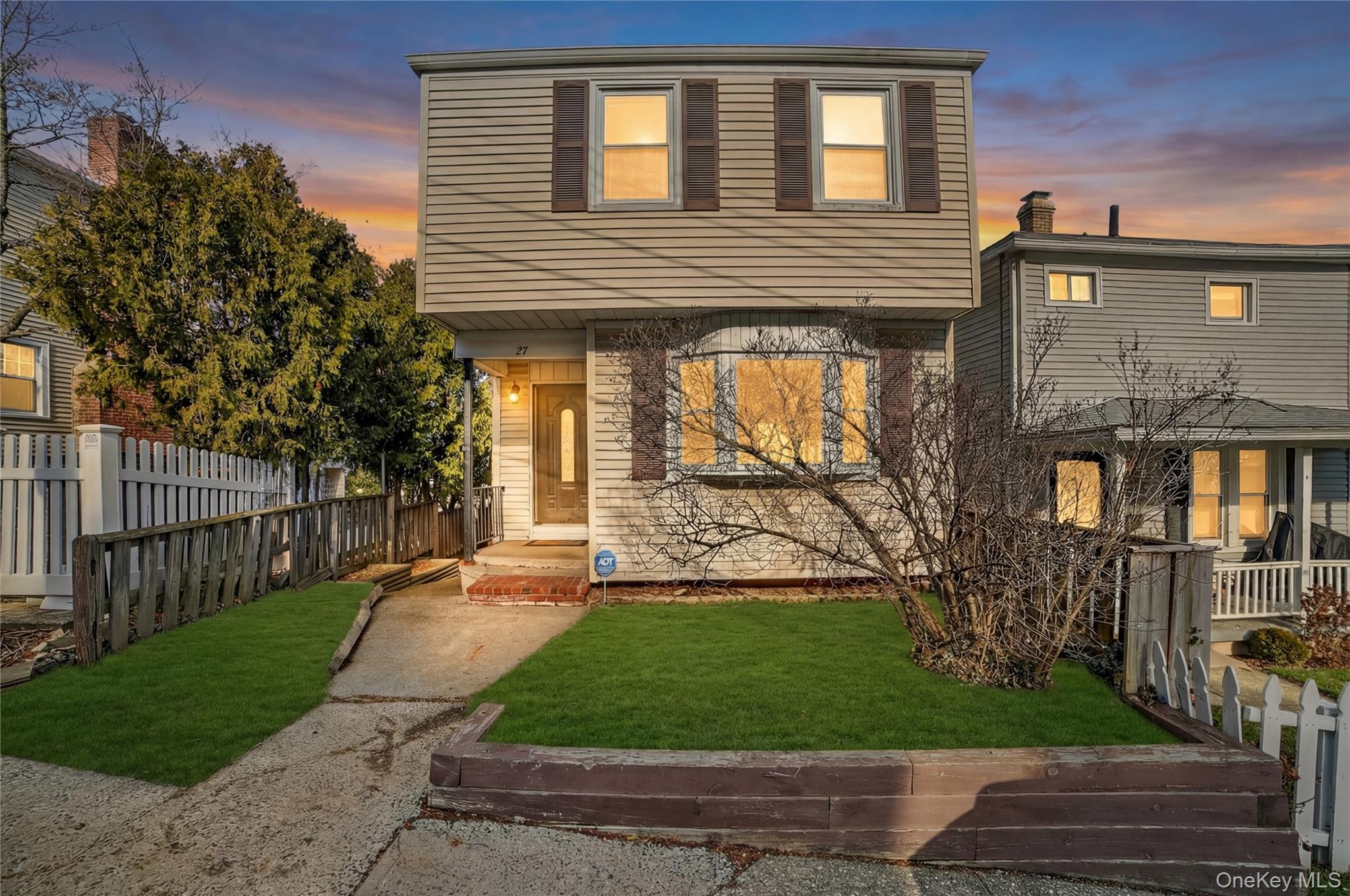 a front view of a house with a yard and potted plants
