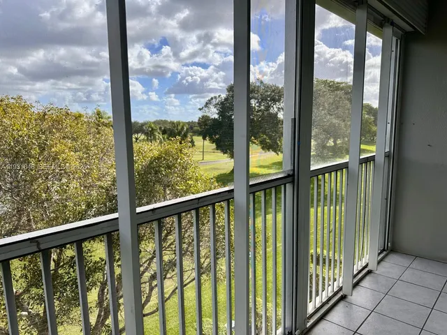 a view of a swimming pool and lounge chairs in the patio