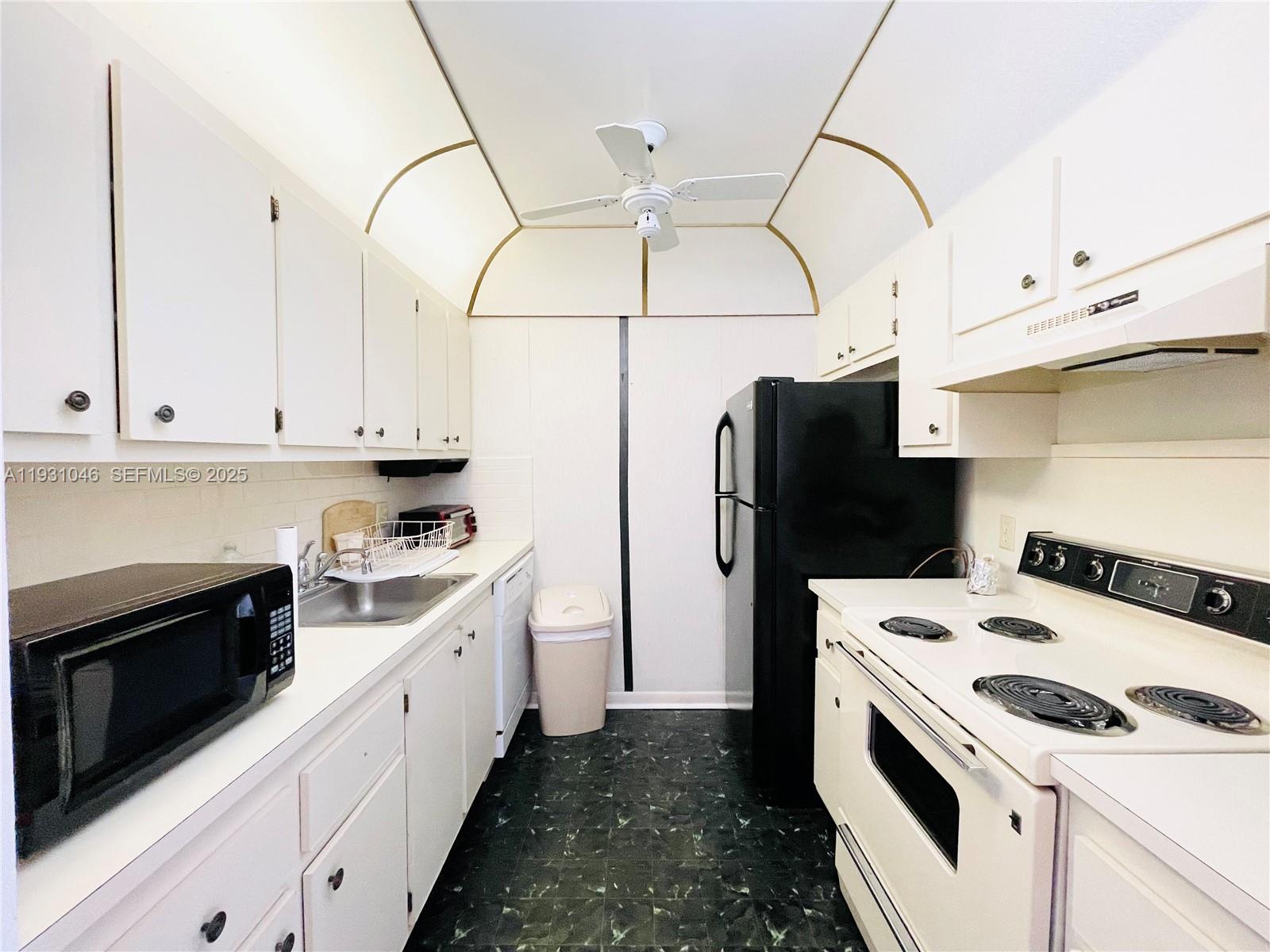 301 Southwest 135th Avenue, Unit 415C Pembroke Pines, FL 33027 - Photo 5 of 13 a kitchen with stainless steel appliances a stove a refrigerator and white cabinets