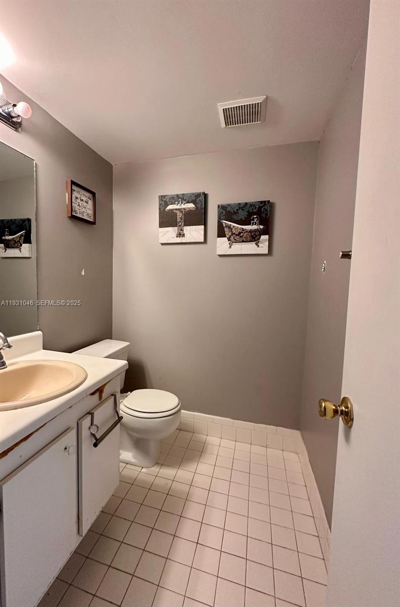 301 Southwest 135th Avenue, Unit 415C Pembroke Pines, FL 33027 - Photo 8 of 13 a bathroom with a toilet a sink and mirror