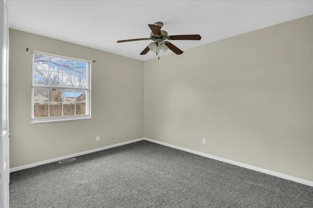 a view of empty room with ceiling fan