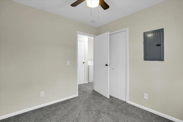 a view of an empty room and chandelier fan