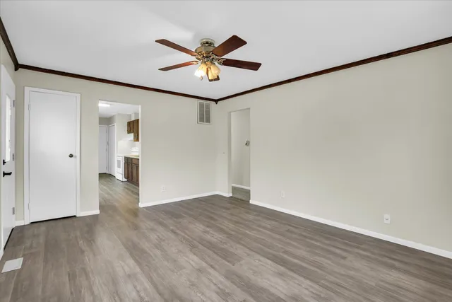 a view of a big room with wooden floor and windows