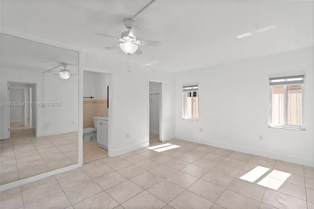 a view of a livingroom with a chandelier fan and windows