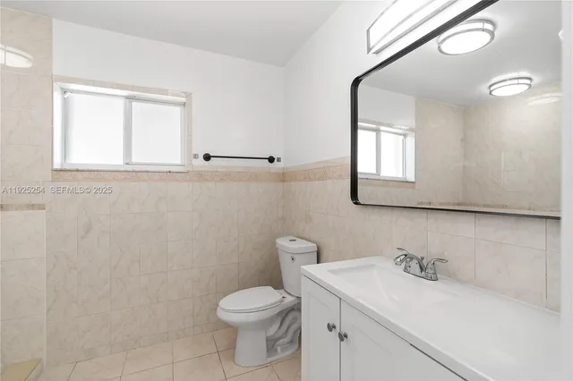 a bathroom with a sink a toilet and a window