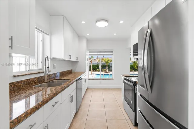 a kitchen with granite countertop a refrigerator and a sink