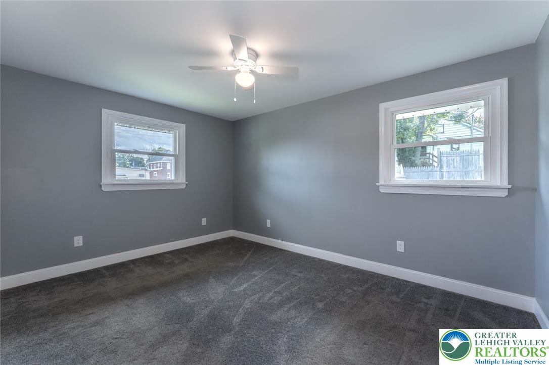 402 Maple Street Roseto, PA 18013 - Photo 23 of 39 Crisp white trim frames multiple windows in this inviting bedroom with plush wall-to-wall carpeting.