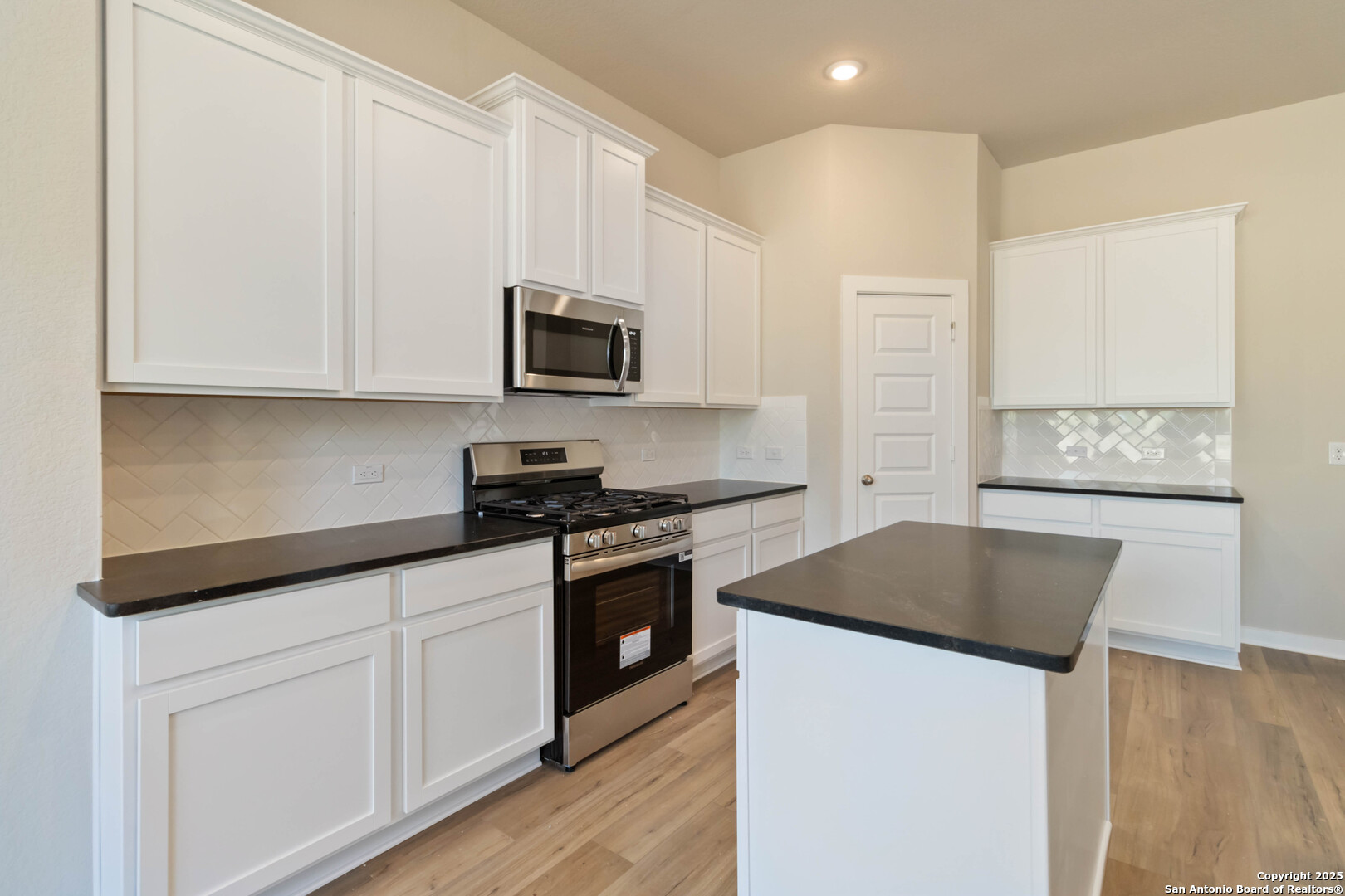 21225 Jordans Ranch Way San Antonio, TX 78264 - Photo 13 of 30 a kitchen with granite countertop white cabinets and stainless steel appliances