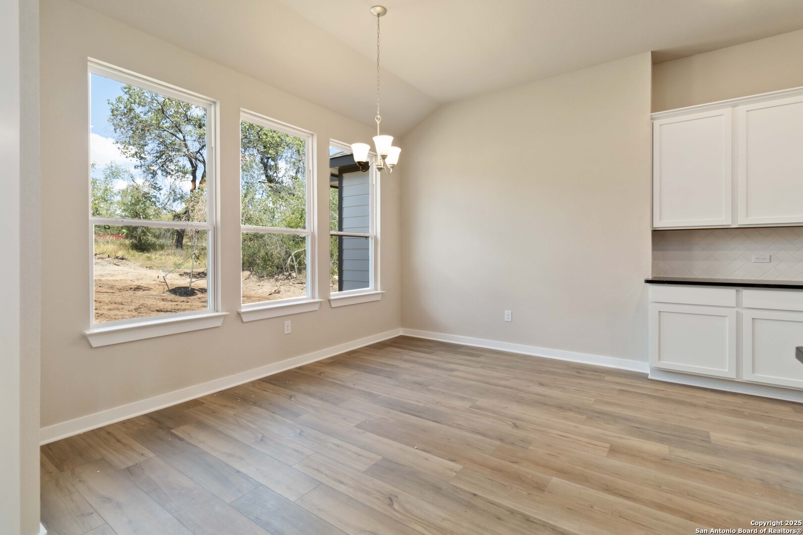 21225 Jordans Ranch Way San Antonio, TX 78264 - Photo 15 of 30 an empty room with wooden floor and windows