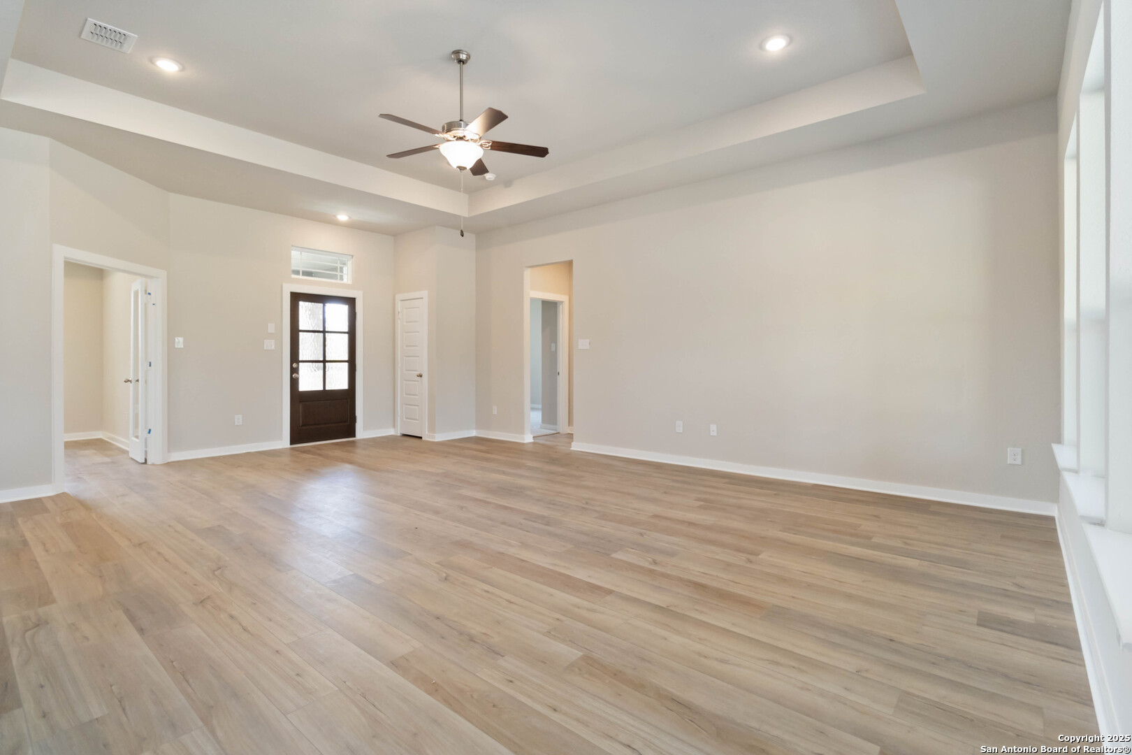 21225 Jordans Ranch Way San Antonio, TX 78264 - Photo 4 of 30 a view of an empty room with wooden floor and a ceiling fan