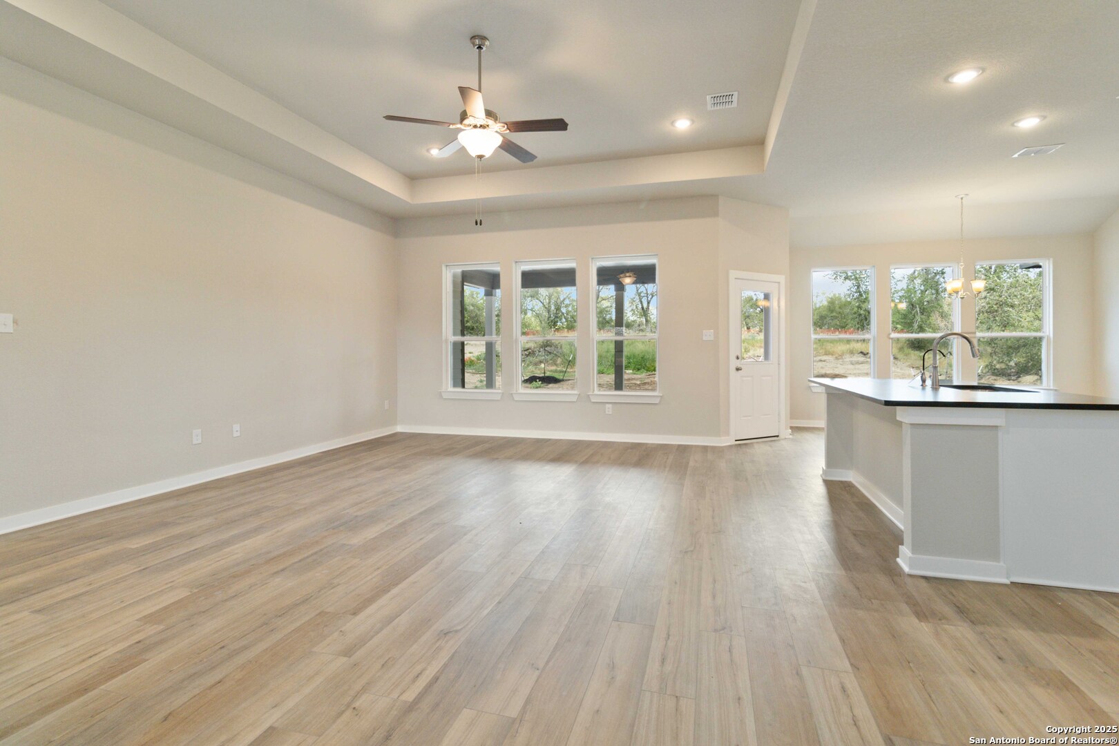 21225 Jordans Ranch Way San Antonio, TX 78264 - Photo 5 of 30 an empty room with wooden floor and windows