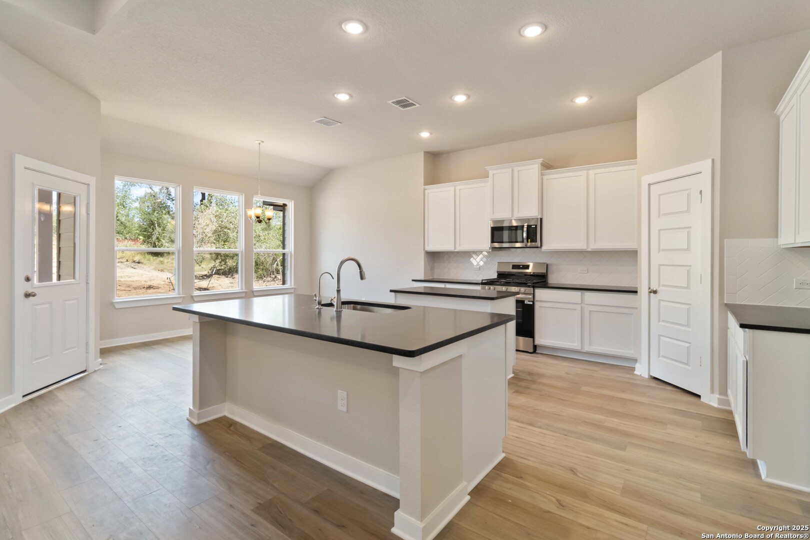 21225 Jordans Ranch Way San Antonio, TX 78264 - Photo 7 of 30 a kitchen with kitchen island granite countertop a sink and appliances
