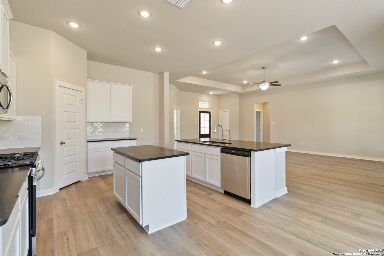 21225 Jordans Ranch Way San Antonio, TX 78264 - Photo 9 of 30 a kitchen with white cabinets and stainless steel appliances