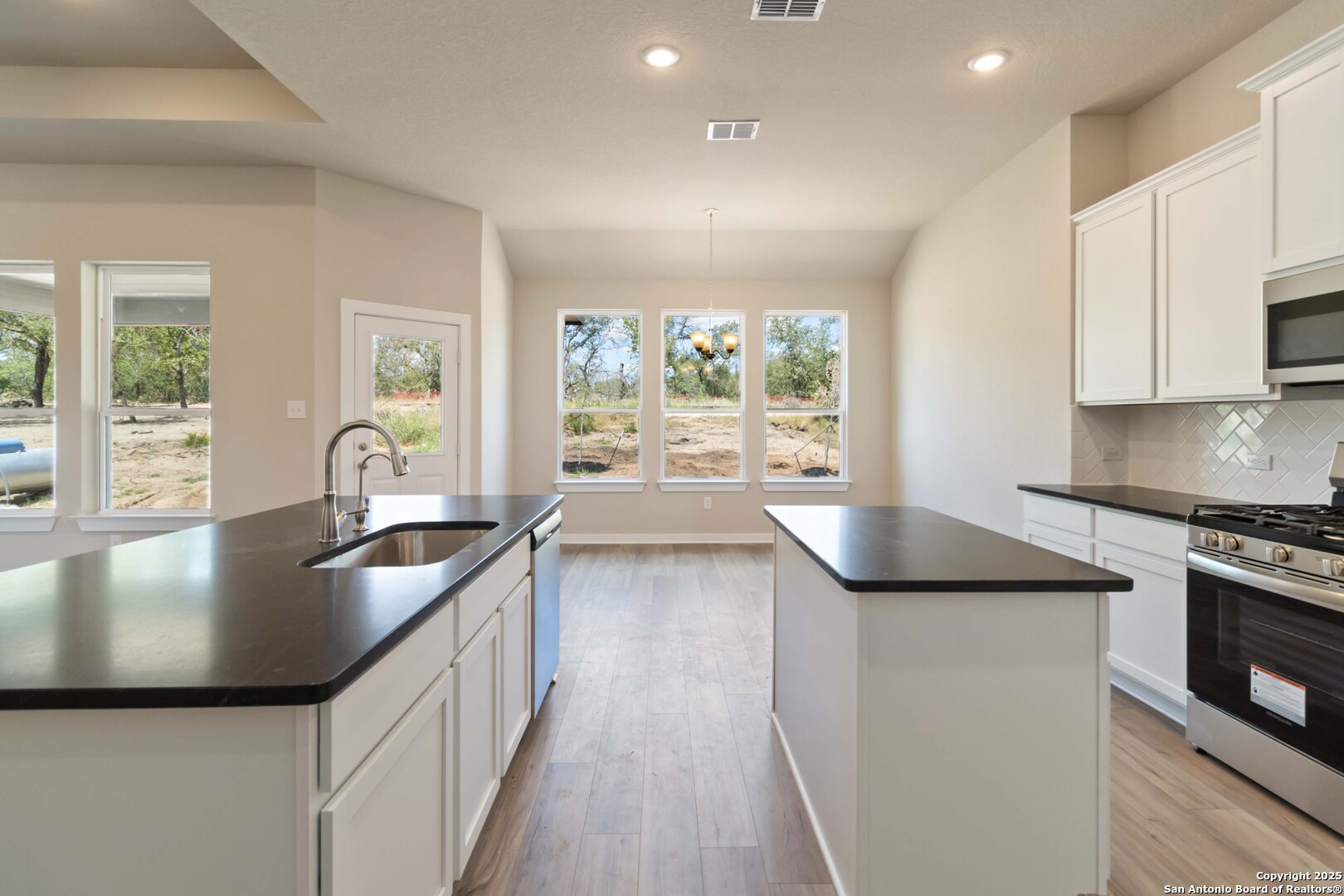 21225 Jordans Ranch Way San Antonio, TX 78264 - Photo 10 of 30 a kitchen with stainless steel appliances granite countertop a sink stove and refrigerator