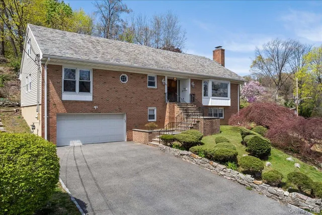 a front view of a house with a garden and plants