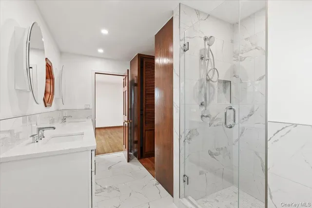 a bathroom with a double vanity sink mirror and shower