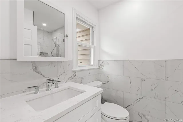 a bathroom with a sink mirror vanity and toilet
