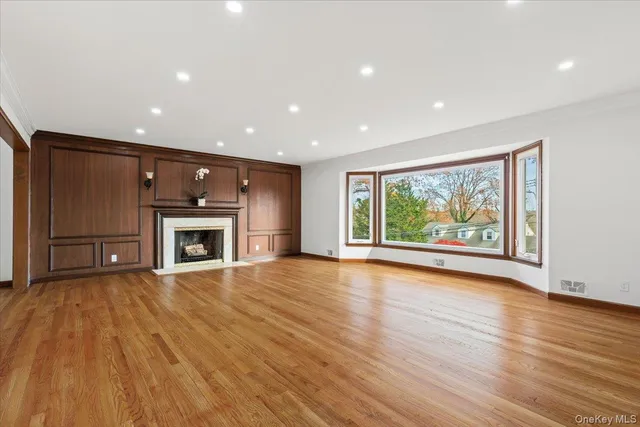 a view of empty room with wooden floor and fireplace