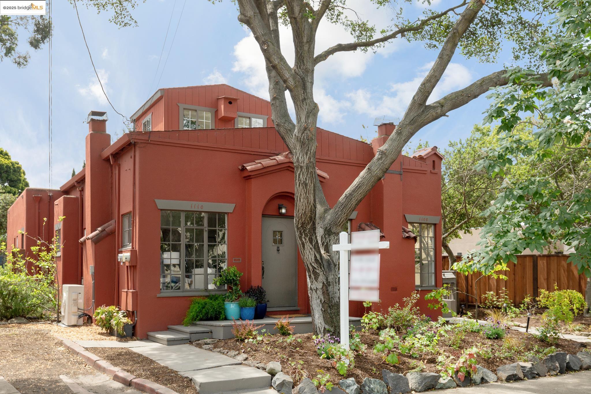 a front view of a house with a tree
