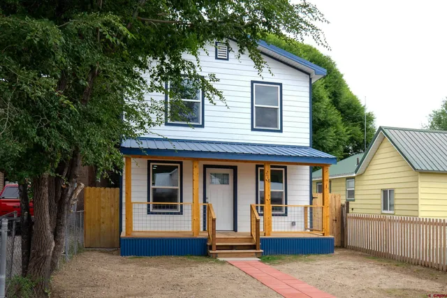 a front view of a house with a tree