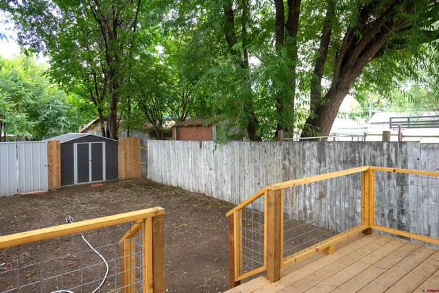 a view of a house with a yard and wooden fence