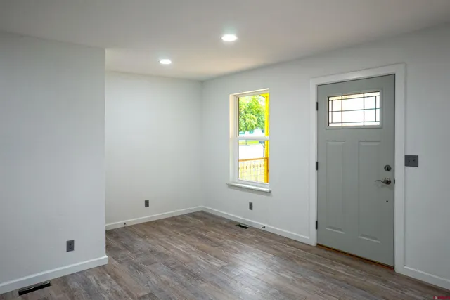 an empty room with a window and wooden floor