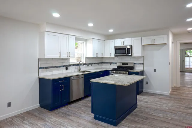 a kitchen with granite countertop a sink stove and cabinets