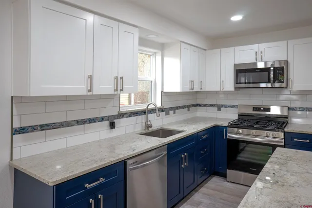 a kitchen with stainless steel appliances granite countertop a sink stove and microwave