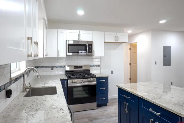 a kitchen with stainless steel appliances a stove sink microwave and refrigerator