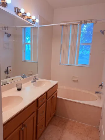 a bathroom with a tub sink and mirror