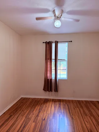 wooden floor in an empty room with a window