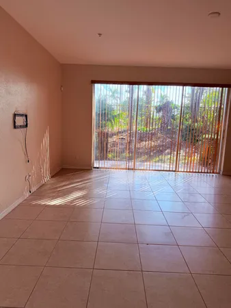 a view of an empty room with a floor to ceiling window and an empty room