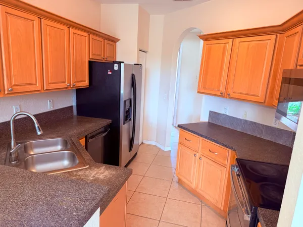 a kitchen with stainless steel appliances granite countertop a sink refrigerator and microwave