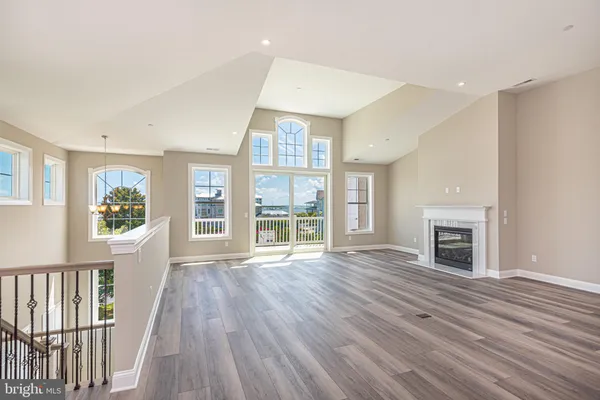 wooden floor fireplace and windows in an empty room