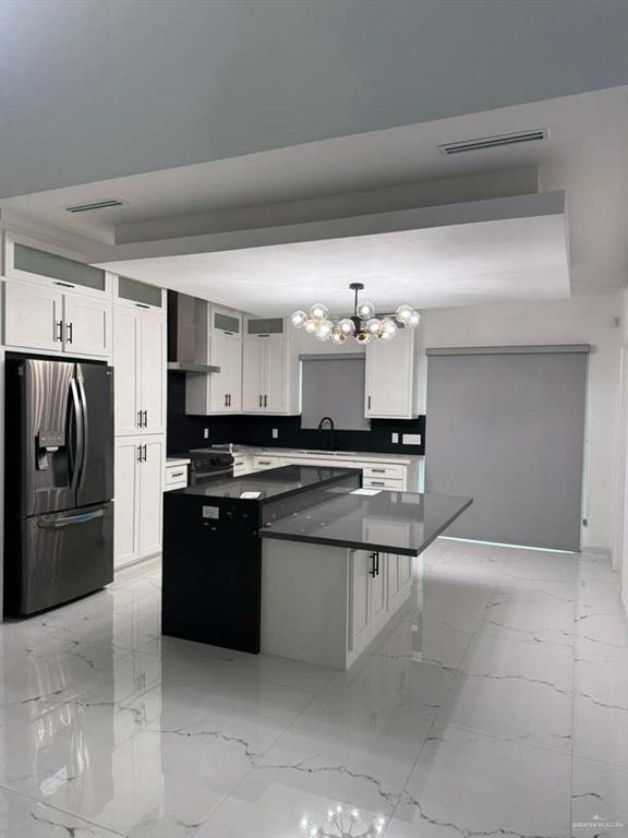 1825 Sunset Drive Mission, TX 78572 - Photo 3 of 12 Kitchen with a kitchen island, stainless steel appliances, white cabinetry, hanging lights, and light marble finish floors
