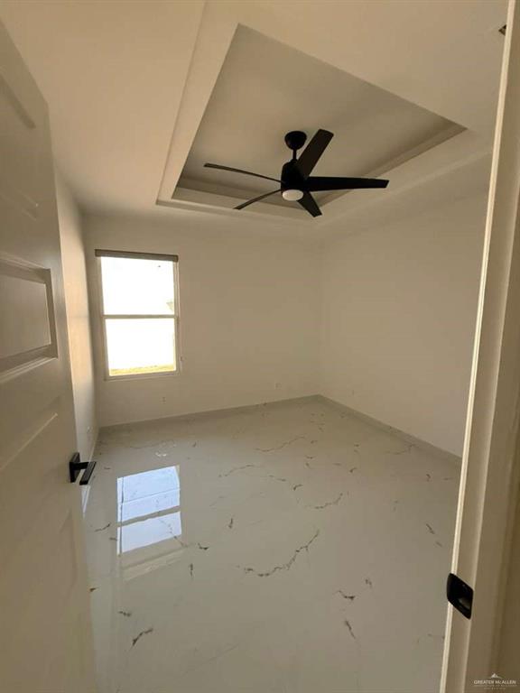 1825 Sunset Drive Mission, TX 78572 - Photo 5 of 12 Empty room with a tray ceiling and a ceiling fan