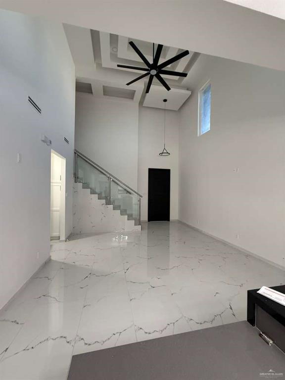 1825 Sunset Drive Mission, TX 78572 - Photo 7 of 12 Unfurnished living room featuring a high ceiling, light marble finish floors, and ceiling fan