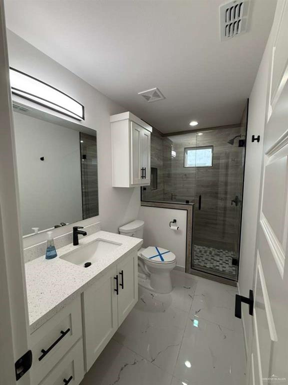 1825 Sunset Drive Mission, TX 78572 - Photo 10 of 12 Full bath with vanity, a stall shower, and light marble finish floors