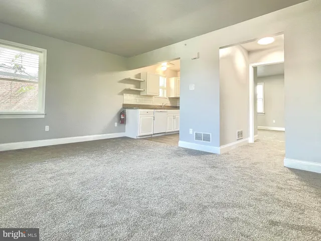 en empty room with windows and entrance