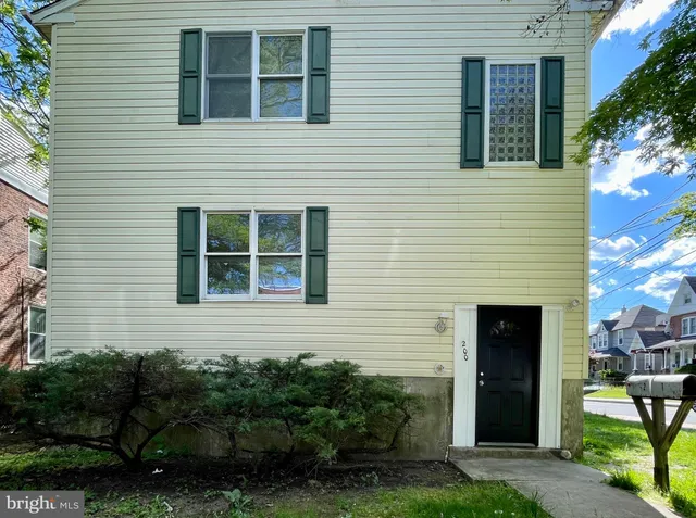 a view of a house with a large tree and a yard