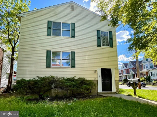 a view of a house with backyard and a tree