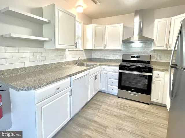a kitchen with granite countertop a stove sink and cabinets