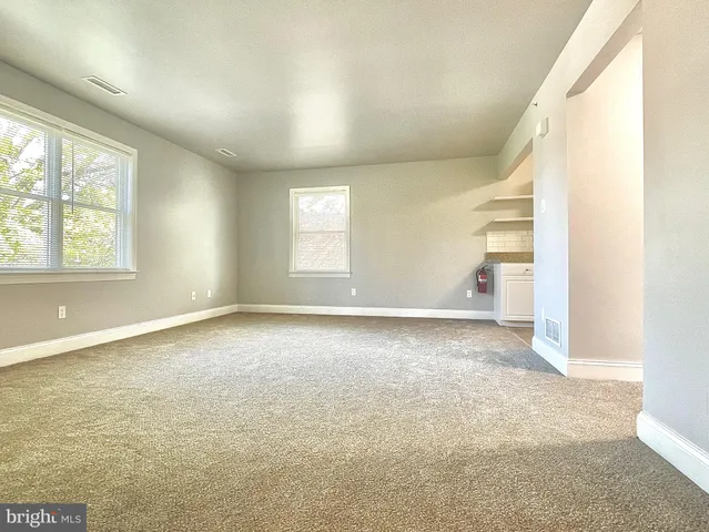 an empty room with windows and closet
