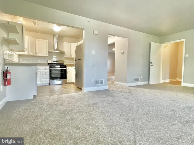 a view of a kitchen with refrigerator and a sink