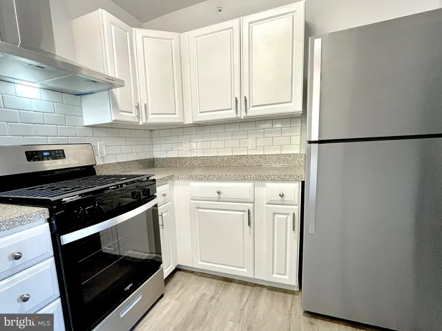 a kitchen with stainless steel appliances white cabinets and a stove