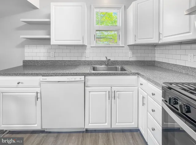 a kitchen with granite countertop white cabinets and white appliances