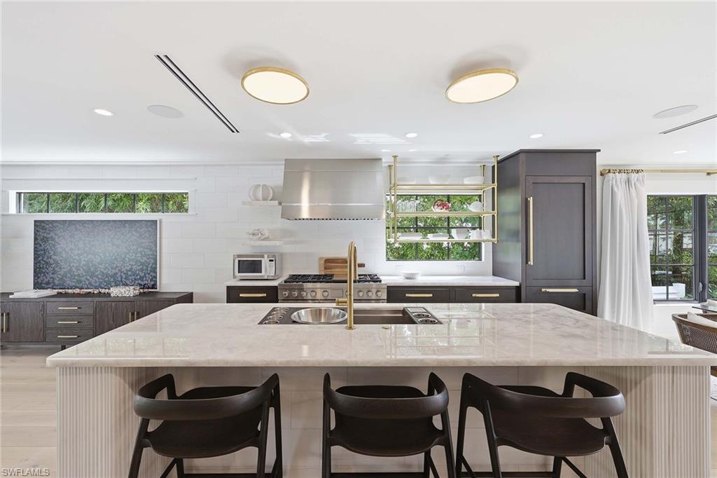 1355 4th Street South Naples, FL 34102 - Photo 24 of 50 a kitchen with a table chairs sink and cabinets