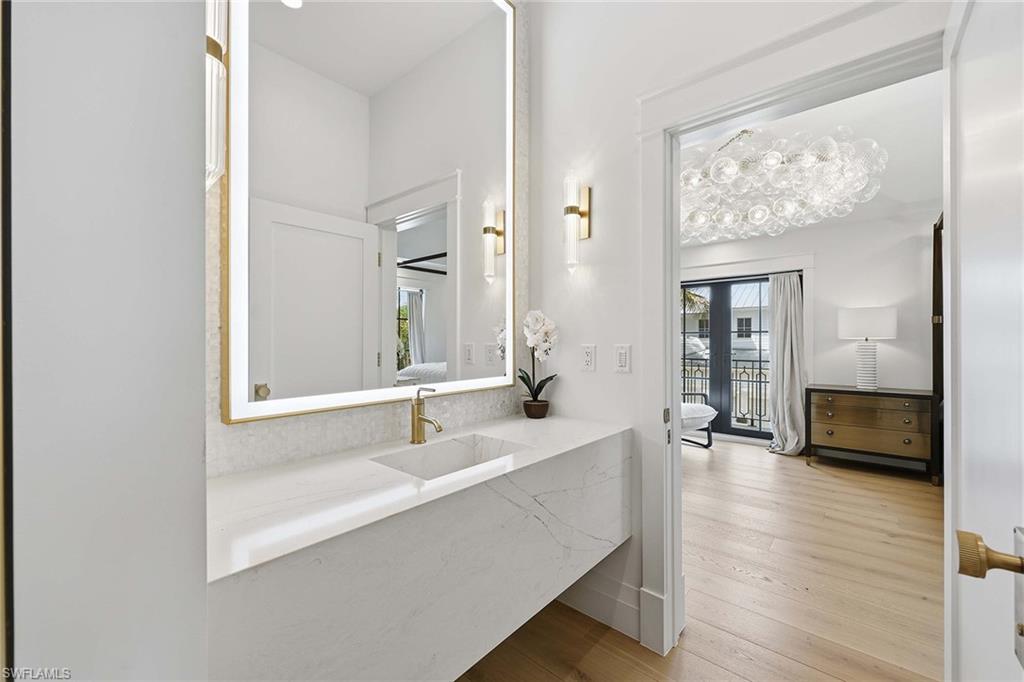 1355 4th Street South Naples, FL 34102 - Photo 31 of 50 a en suite bathroom with a sink and a large mirror