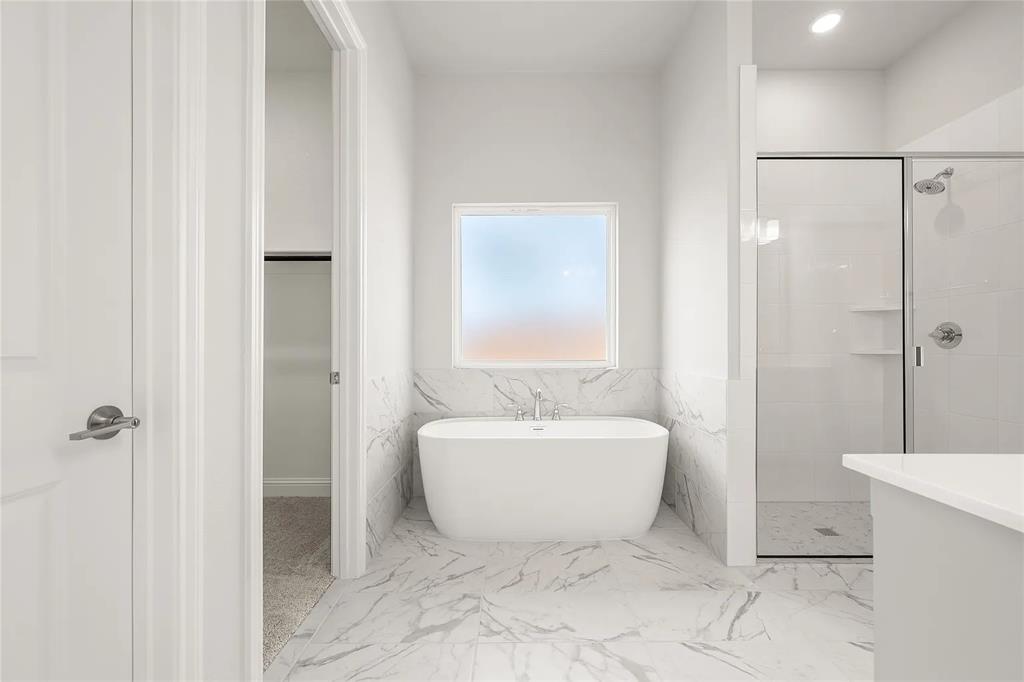 4021 Alpine Street Midlothian, TX 76065 - Photo 10 of 18 Bathroom featuring a freestanding soaking tub, marble-look tile flooring, and a walk-in shower with a glass enclosure